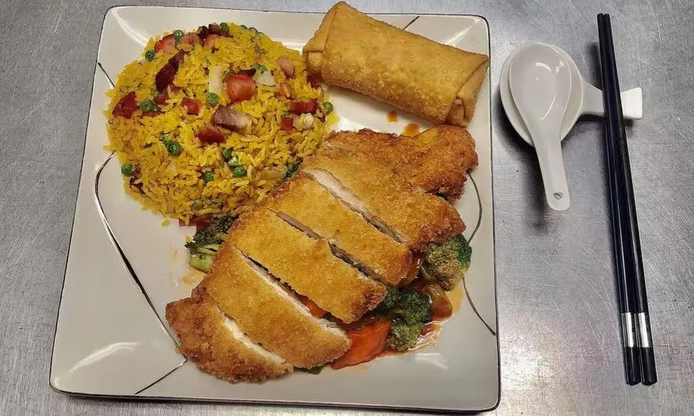 Fried Chicken Chop with Fried Rice and Spring Roll Golden fried chicken chop served with yellow rice and spring roll at Double Delight, a Chinese Restaurant restaurant in Brooklyn