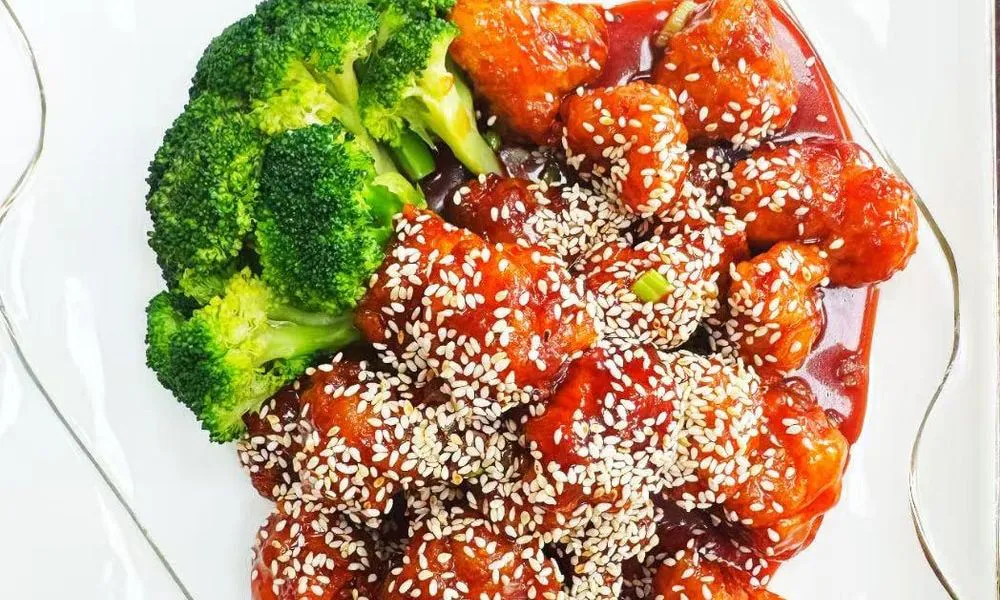 Sweet and Sour Chicken Succulent chicken pieces in a sweet and sour sauce, garnished with sesame seeds at Double Delight, a Chinese Restaurant restaurant in Brooklyn