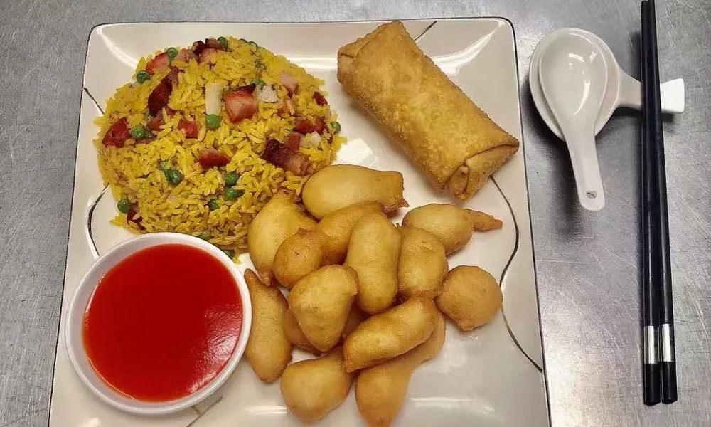 Fried Rice and Spring Roll Yellow fried rice with vegetables and meat, spring roll, and sweet and sour sauce at Double Delight, a Chinese Restaurant restaurant in Brooklyn