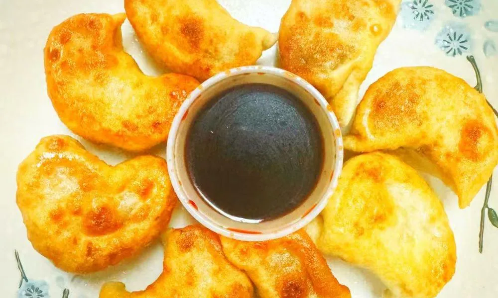 Potstickers Golden-brown fried dumplings with dipping sauce at Double Delight, a Chinese Restaurant restaurant in Brooklyn